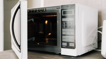 A white microwave oven with a digital display and various control buttons, including a grill function.