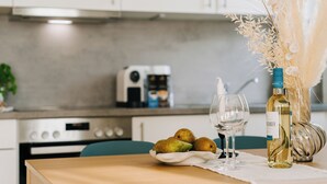 A kitchen with a modern design, featuring a stove, a coffee maker, and a bowl of fruit on the counter. - NEW-Mia - pure relaxation in Bavaria's charm (Kemnath)