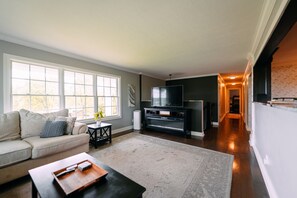A living room with a sofa, coffee table, TV, and fireplace.
