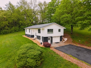 A two-story house with a front porch, a garage, and a driveway.