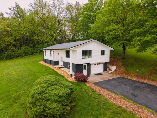 A two-story house with a front porch, a garage, and a driveway.