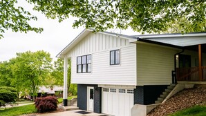 Et toetagers hus med garage, overdækket veranda og anlagt have.
