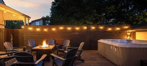 An outdoor deck with a fire pit, seating, and a hot tub. - The Paper Plane ~ Hot Tub, Fire Pit, Deck, Grill (Louisville)