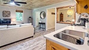 A modern kitchen with a stainless steel sink, wooden cabinets, and a ceiling fan. - Cute'N Chic 4b/2b Entire House Downtown Clayton GA (Clayton)