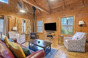 A cozy cabin interior with wooden walls, a fireplace, a television, and comfortable seating. - Shadyside Cabin | Hocking Hills, Hot Tub, Firepit (Laurelville)