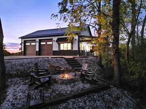 A modern house with a fire pit and outdoor seating.