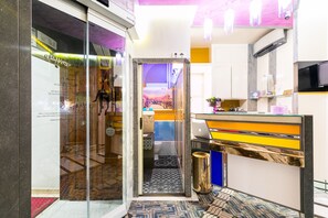 A modern bathroom with a glass door, a patterned floor, and a sink with a colorful countertop. - Appartamenti MarcoAurelio49 (Rome)
