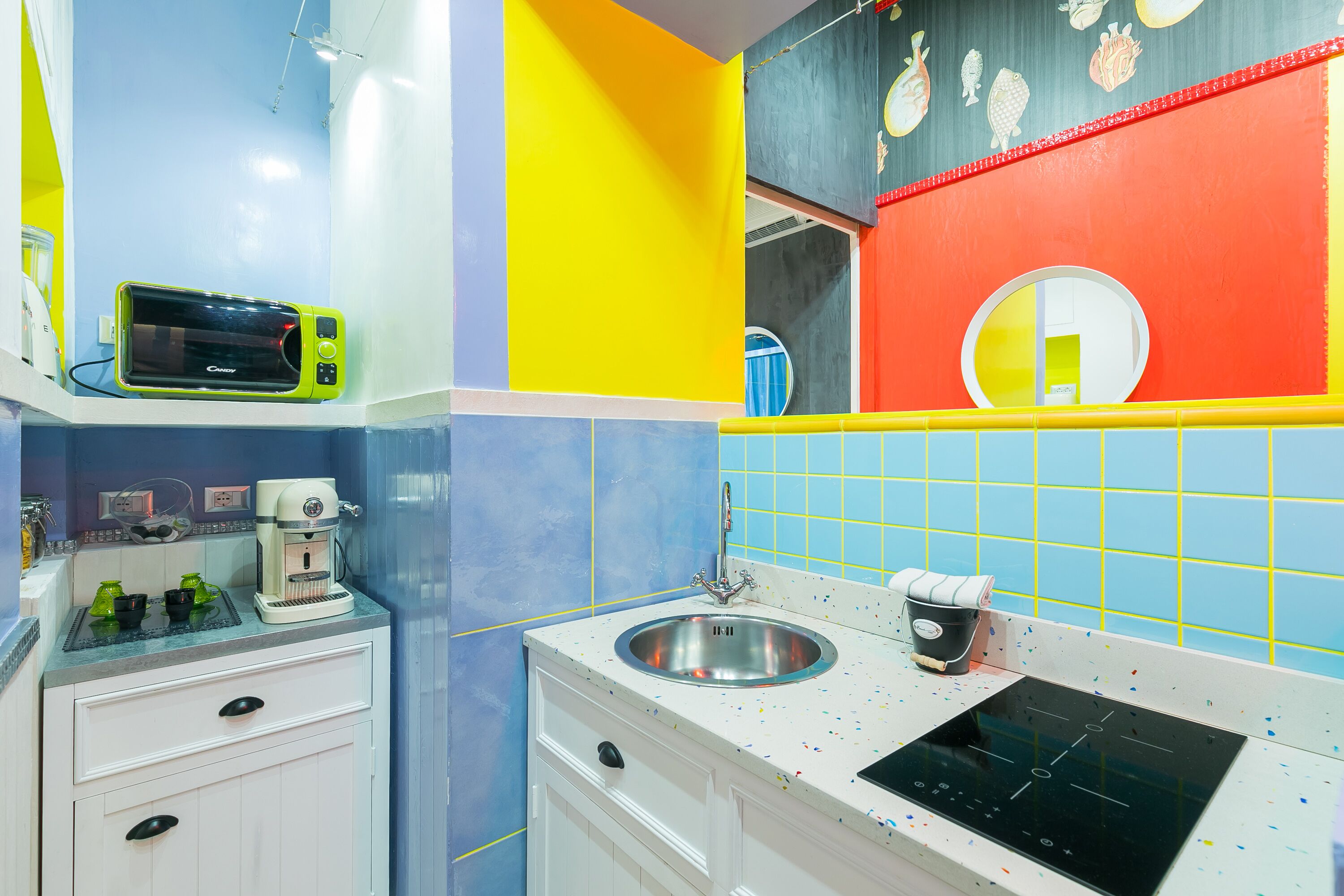A kitchen with a microwave, coffee maker, sink, and stove.