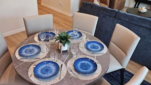A dining area with a round table set for six, surrounded by six chairs. - Stylish 4BR Home, perfect for families, professionals, business & group stays. (Sherman)
