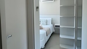 Un couloir menant à une chambre à coucher équipée d’un lit, d’une table de chevet et d’une armoire.