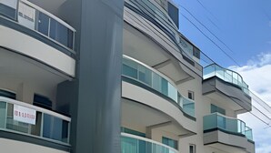 Un immeuble à plusieurs étages, doté de balcons, d’un escalier et d’une enseigne dans une langue étrangère.