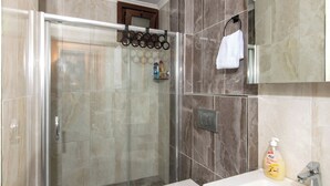 A modern bathroom with a glass-enclosed shower, a white toilet, a sink with a mirror, and a towel rack. - FAMILY HOME (İstanbul)