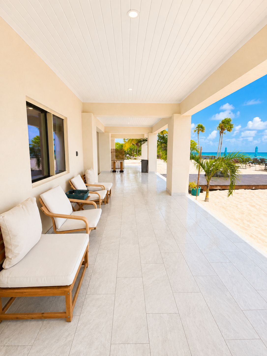A covered outdoor seating area with chairs and a view of the beach.