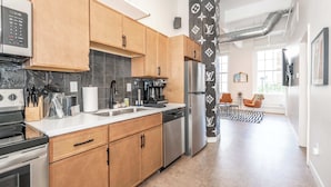 A modern kitchen with wooden cabinets, stainless steel appliances, and a central island. - The 333 Suites 301 - Suite for 6 (Cincinnati)