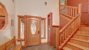 A wooden staircase with a handrail, a wooden bench, and a door with a glass panel. - Knotty by Nature - Hot Tub, Pets & Fun - Oh my! (South Lake Tahoe)