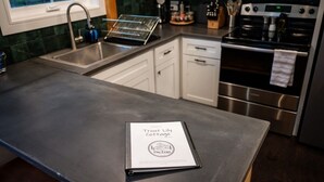 Una cocina moderna con electrodomésticos de acero inoxidable, horno empotrado y pileta.