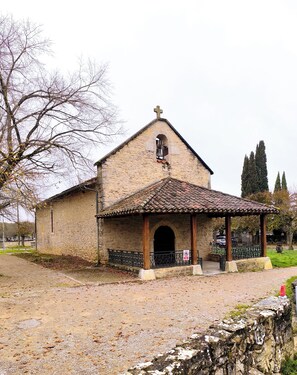 A stone church with a tiled roof and a small porch. - Casa Liã Guest House (Septfonds)