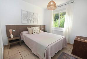 A bedroom with a bed, bedside tables, a window with curtains, and wall art. - Panoramic views, 2 km from the beach, pools open year-round. Free parking space. (Calp)