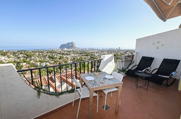 A balcony with a table and chairs, a view of a cityscape and a mountain. - Panoramic views, 2 km from the beach, pools open year-round. Free parking space. (Calp)
