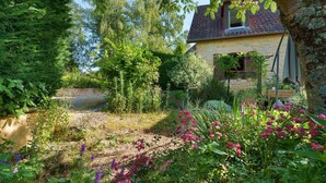 A stone house with a garden, a wooden bench, and a tree. - Holiday Home 'Écrin de Verdure' with Private Terrace, Shared Garden and Wi-Fi (Sarlat-la-Canéda)