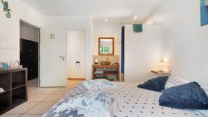 A bedroom with a bed, a nightstand, a dresser, a door with a letter 'B', a mirror, and a window. - Bed and Breakfast 'Chambre Bleue' with Shared Pool, Shared Terrace and Wi-Fi (Saint-André d'Allas)