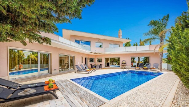 A modern two-story house with a swimming pool, outdoor seating, and a view of the surrounding landscape. - Villa Caripira by Villa Plus (Albufeira)