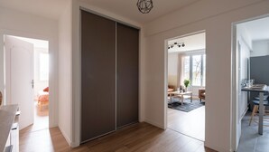 Een modern interieur met een schuifdeur, een eethoek met tafel en stoelen, en een keuken met een aanrecht en krukken.