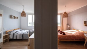 Een slaapkamer met een bed, nachtkastje en raam.