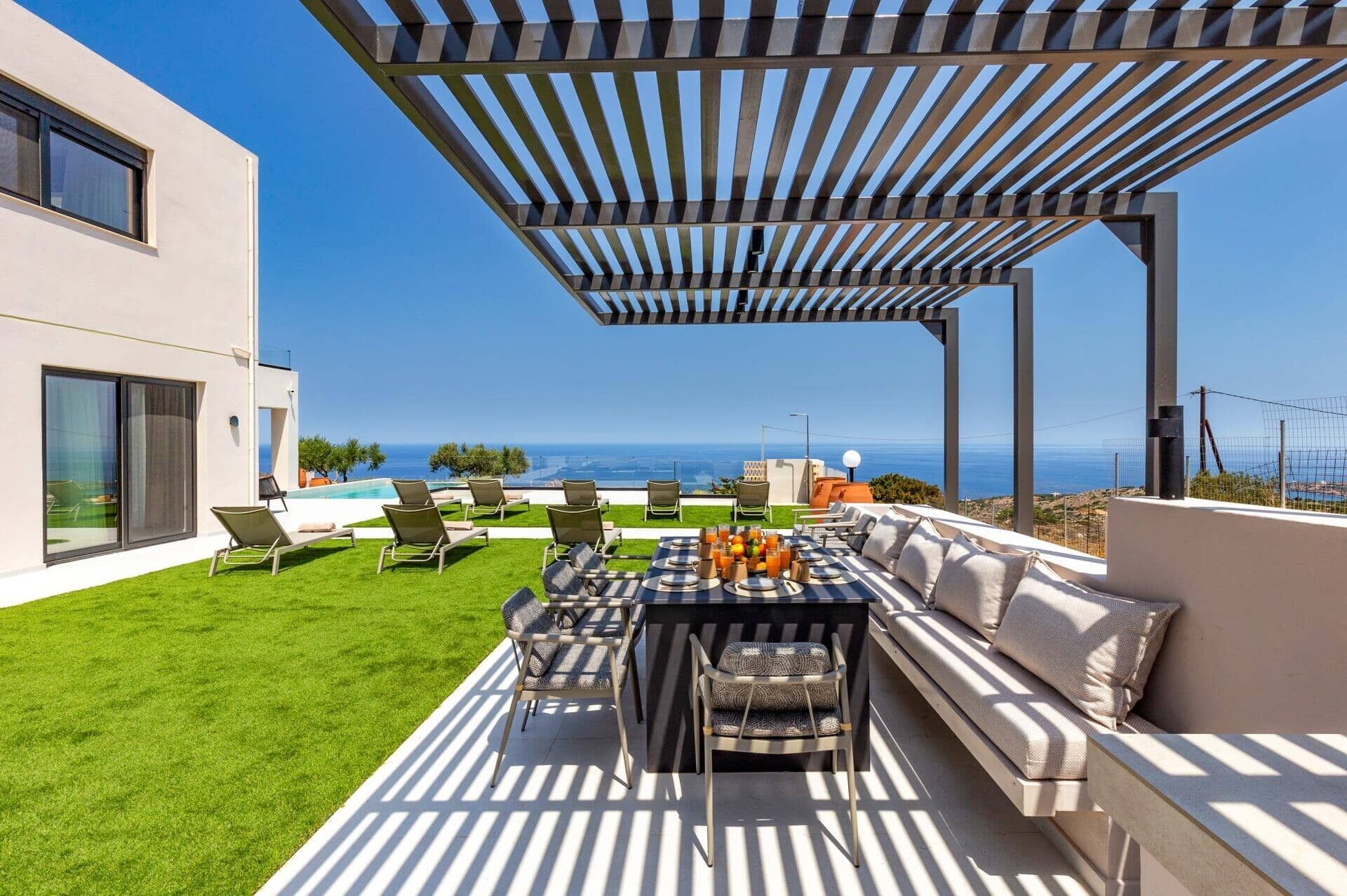 Um pátio moderno ao ar livre com piscina, área de estar e vista para o oceano.