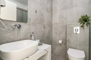 Ein modernes Badezimmer mit freistehender Badewanne, Toilette und Waschbecken.