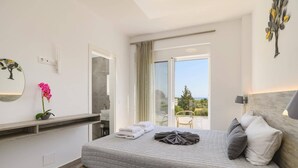 Ein Schlafzimmer mit Bett, Bad und Balkon mit Aussicht.