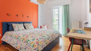 Un dormitorio con cama, escritorio y ventana.