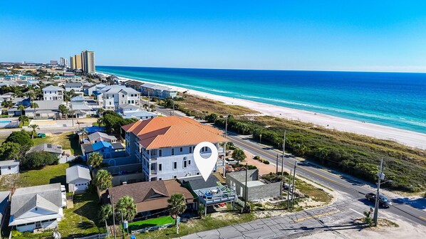 Vista aérea de una zona residencial costera con casas, una playa y una carretera.