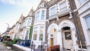 A row of Victorian-style townhouses with bay windows, a stone facade, and a gated entrance. - Modern Studio with Fast Wifi! (Cardiff)