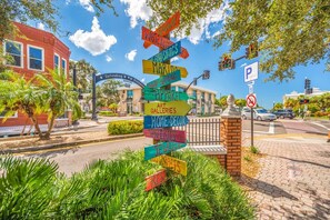 A colorful directional signpost with various destination labels. - Walk Downtown | Private Patio | Pool | Pets | Skye (Dunedin)