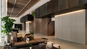 Een moderne lobby met een bank, salontafel en potplanten.