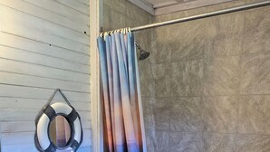 A bathroom with a shower, toilet, and sink. - Cabin - Older/Simple/Rustic/No Frills/Budget 2 Bedroom - Near Cabot Beach Park (Kensington)