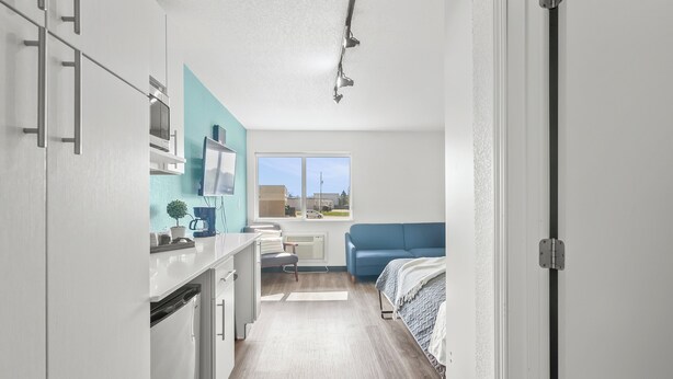 A modern kitchen with white cabinets, a countertop, and a window with a view of the outside. - Chic 1-bedroom Micro Studio Apartment (Cedar Falls)