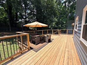 A wooden deck with outdoor furniture and a large umbrella. - Perfect Location, Minutes to everything Alpharetta & Johns Creek (Alpharetta)