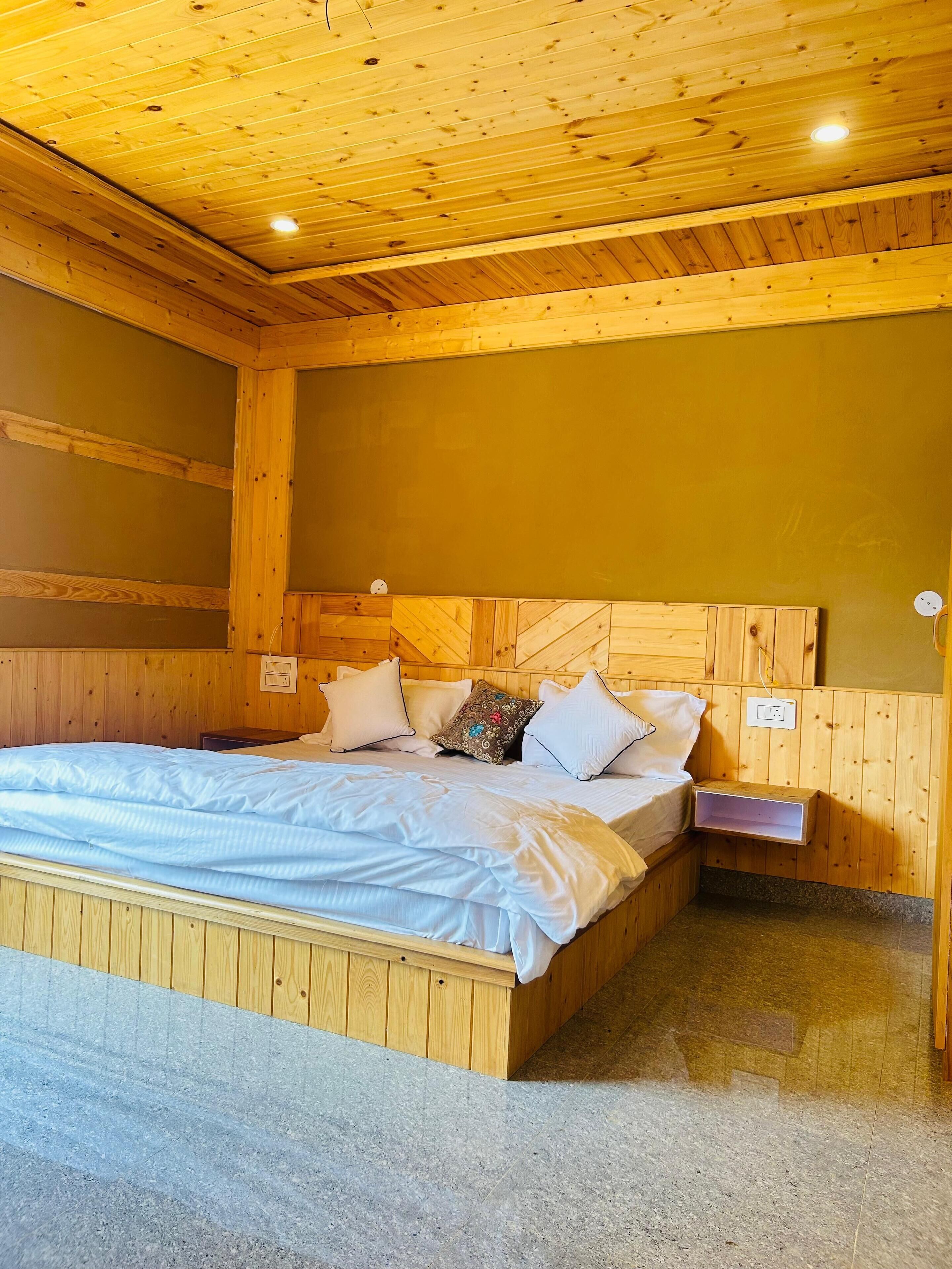 A wooden-paneled bedroom with a bed, pillows, and a nightstand.