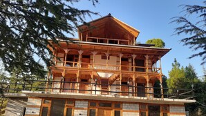 Un immeuble à plusieurs étages doté d’une façade en bois, de balcons et de grandes fenêtres.