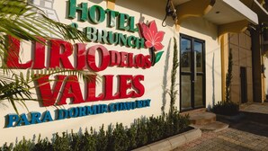 A hotel sign with the name "Hotel Brunch Cirios de los Valles" and a tagline "Para Dormir Conmigo". - Hotel & Brunch Lirio de los Valles (Flores)