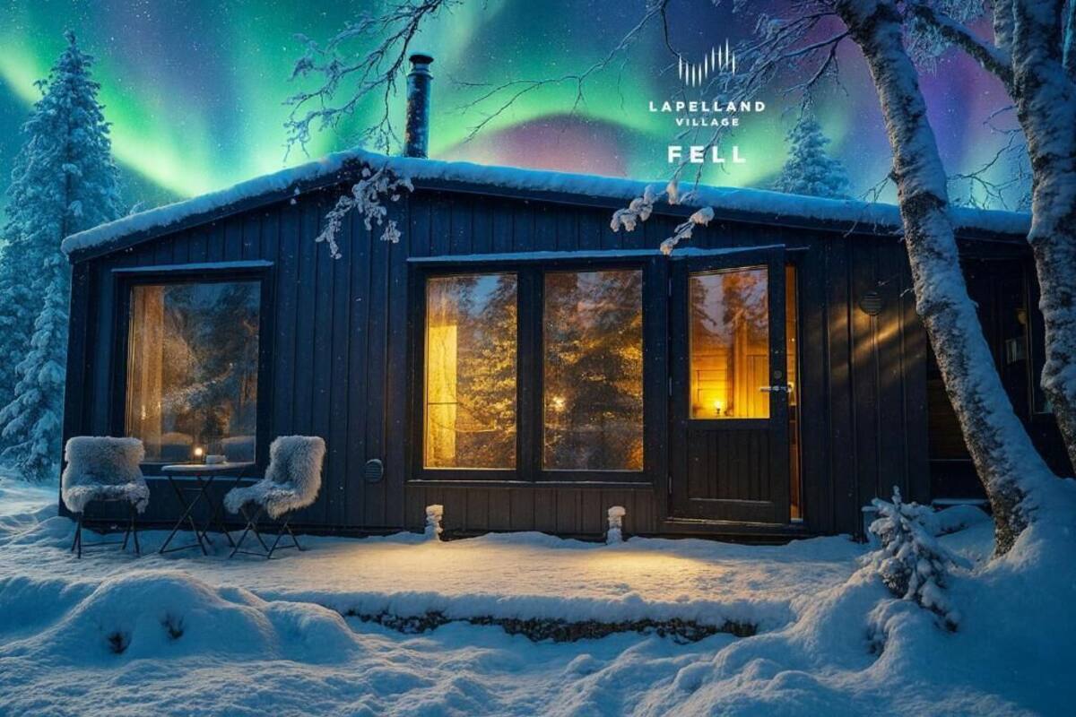 A wooden cabin with large windows, a fireplace, and a snow-covered landscape.