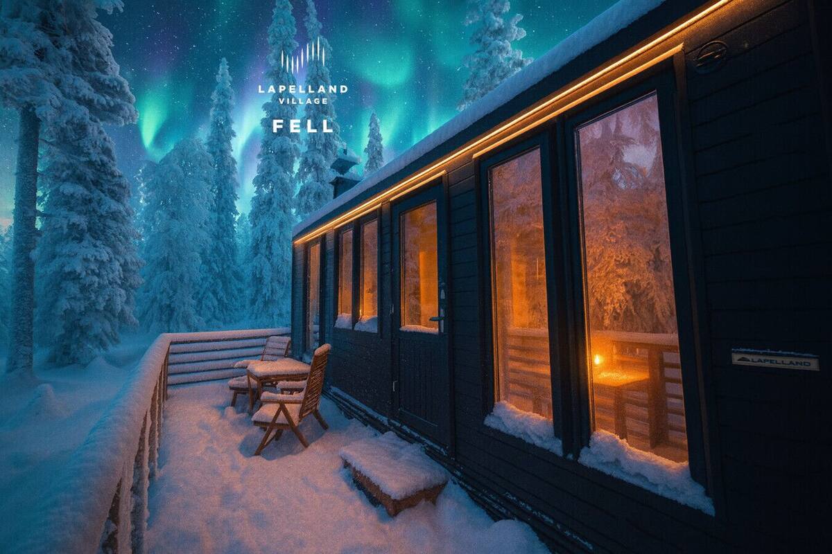 A cozy cabin with a snow-covered deck and a view of the Northern Lights.