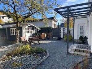 A patio area with a pergola, wooden benches, and a gravel pathway. - Bergfreiheit 61 (Winterberg)