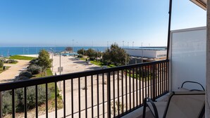 A balcony with a view of a beach and a parking lot. - Wanderlust by Monholiday (Monopoli)