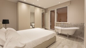 A modern bedroom with a large bed, a built-in bathtub, and a mirror. - Wanderlust by Monholiday (Monopoli)
