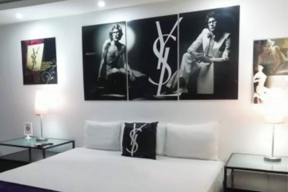 A hotel room with a large bed, two bedside tables, and three wall-mounted artworks.