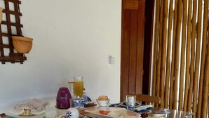 A dining table with chairs, a wooden floor, and a bamboo curtain. - Recanto Verde (Mata de Sao Joao)