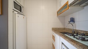 A kitchen with a microwave, refrigerator, sink, and stove. - Apts in a Building 100 Meters From Ufsc - Eoss (Florianópolis)